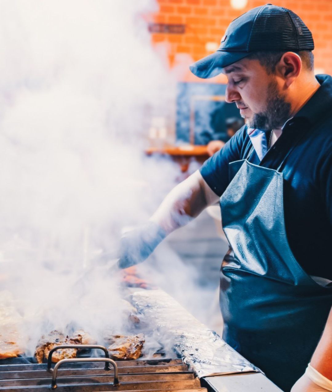 Chef de Limón & Café preparando carnes a la parrilla con dedicación